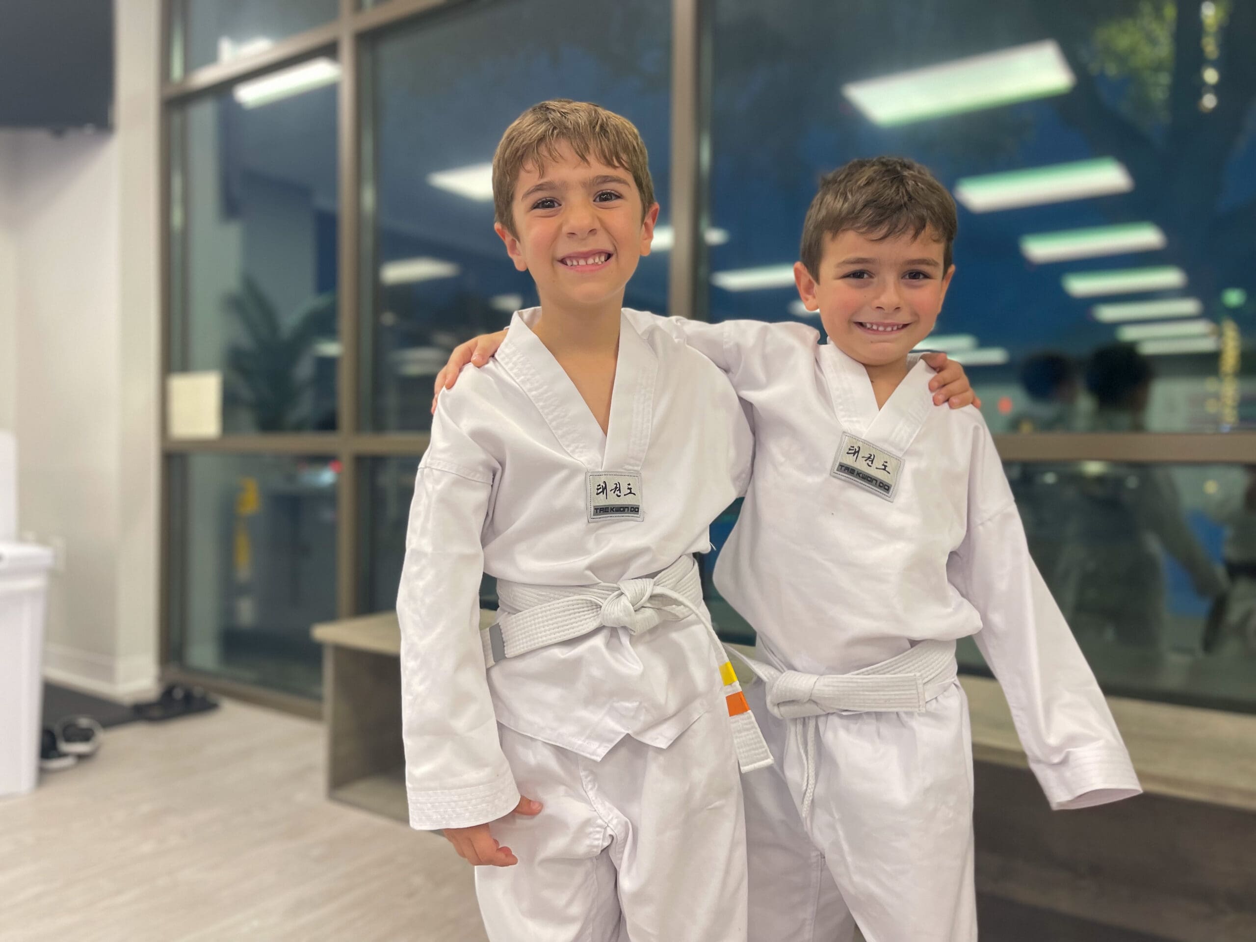 A child attending a martial arts preschool and practicing Taekwondo benefits from self-defense skills, self-esteem, motor skills development, and discipline, while using protective gear like shin guards to safely learn hand strikes and build self-confidence with a positive impact on their growth.
