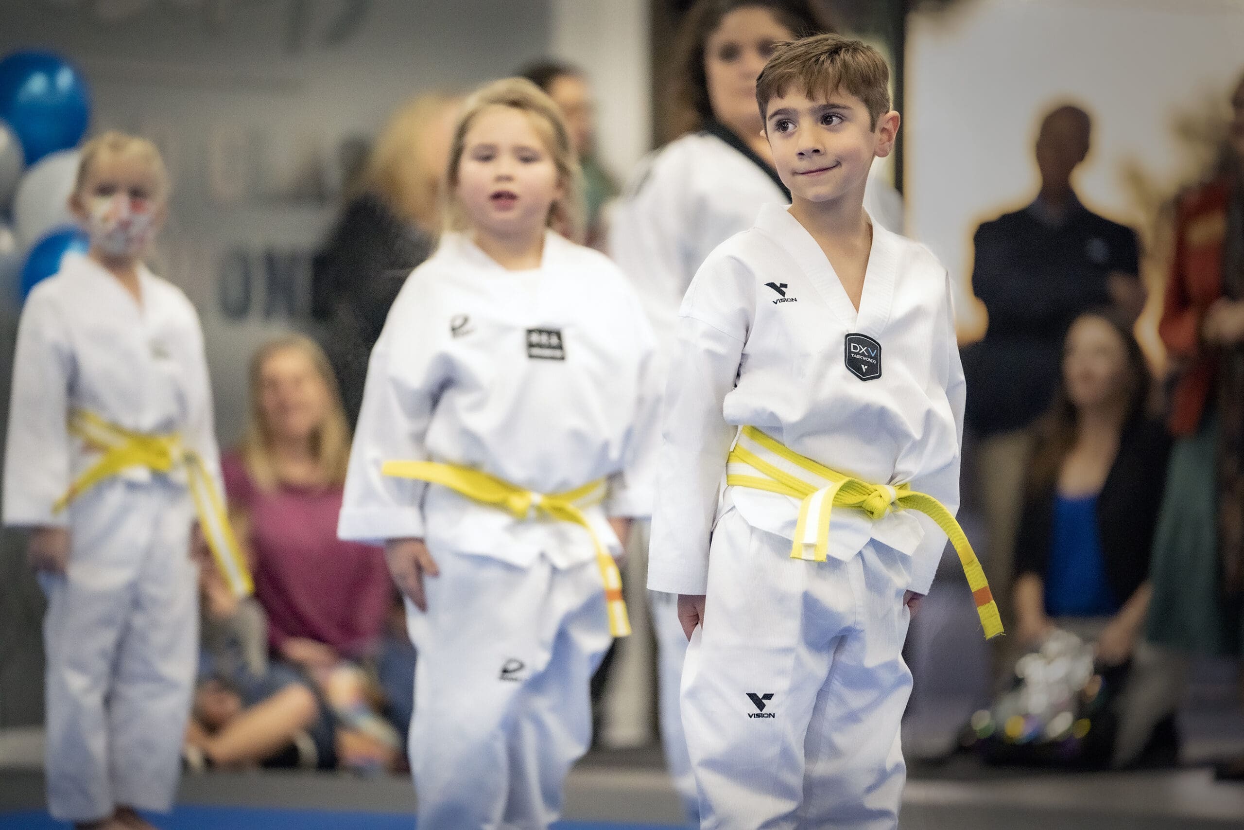 Korean martial arts, especially Taekwondo, provide essential life skills through structured training led by experienced instructors, teaching self-defense, improving gross motor skills, supporting mental development, and introducing students to Korean culture; with the use of protective gear like shin guards, wooden boards for breaking, and the belt system, students at every developmental stage can learn new techniques while wearing their Taekwondo uniform.