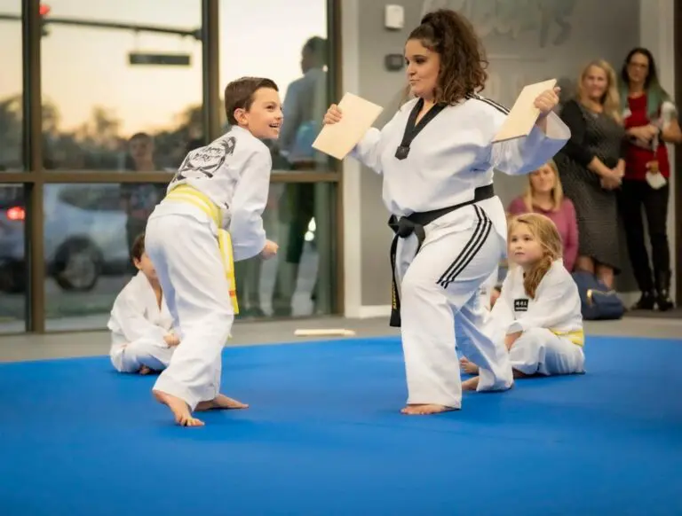 young taekwondo class student breaking a board