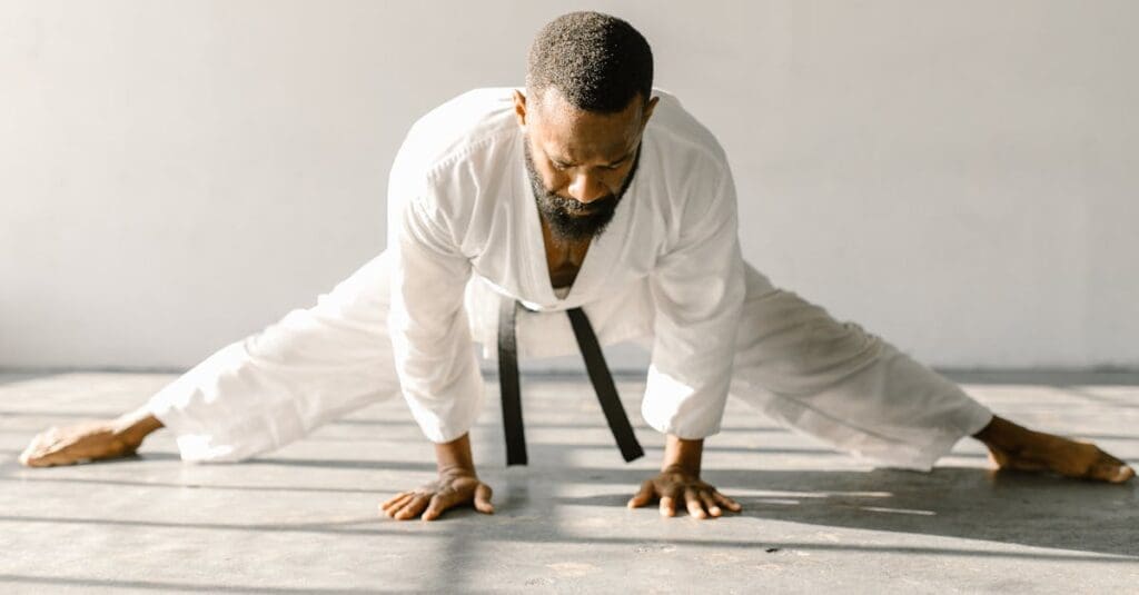 Martial artist stretching legs to improve flexibility for taekwondo kicks
