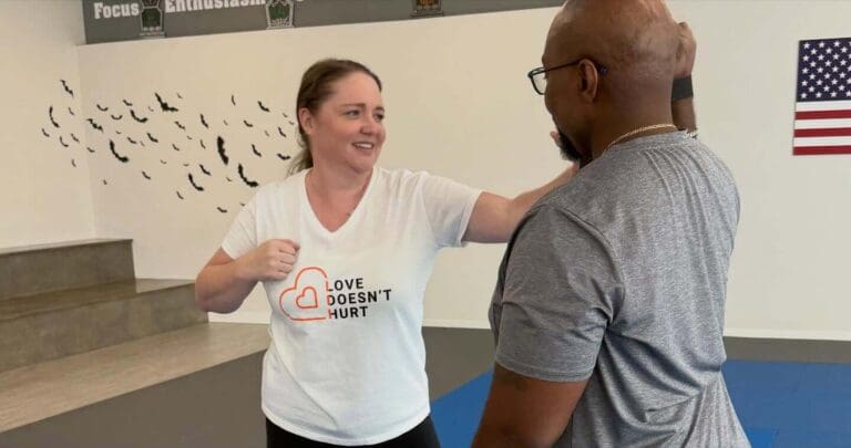 Adult practicing a defensive striking technique with a training partner during a self-defense class focused on avoiding common protection errors, adult self defense mistakes.