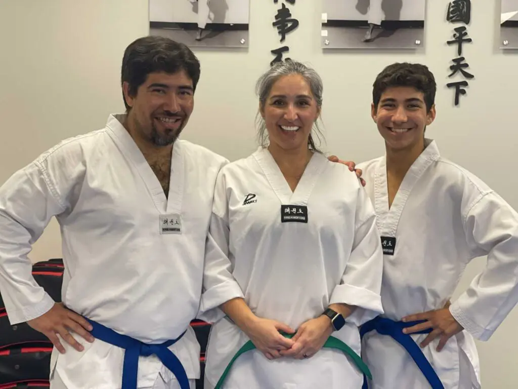 Adult martial arts students posing together after training in a karate dojo during an adult self defense situational awareness class