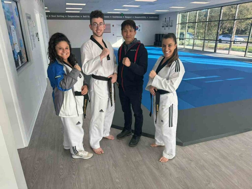 Adult martial arts students and an instructor posing together inside a training studio after class, what happens in an adult martial arts class